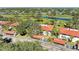 Aerial of red-roofed condos next to the golf course and pond with mature trees surrounding at 3500 El Conquistador Pkwy # 119, Bradenton, FL 34210