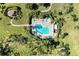 Community pool with surrounding patio, hot tub, and lush landscaping at 3500 El Conquistador Pkwy # 119, Bradenton, FL 34210