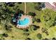 Aerial view of community pool, patio area with lounge chairs, and lush landscaping at 3500 El Conquistador Pkwy # 119, Bradenton, FL 34210