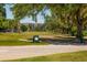 Scenic view of the golf course featuring a golfer teeing off surrounded by mature trees at 3880 Ironwood Ln # 408E, Bradenton, FL 34209