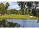 Scenic view of the golf course with a peaceful lake in the foreground, and a golf cart in the distance at 3880 Ironwood Ln # 408E, Bradenton, FL 34209