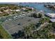 Aerial view of tennis courts with players and surrounding palm trees at 419 Partridge Cir, Sarasota, FL 34236