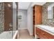 Modern bathroom with glass shower, mosaic tile, and wood cabinets at 419 Partridge Cir, Sarasota, FL 34236