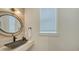 Modern bathroom with black vessel sink, round mirror, and white walls at 421 Pine Ave, Anna Maria, FL 34216