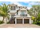 Beautiful two-story home with a metal roof, two-car garage, and brick driveway at 421 Pine Ave, Anna Maria, FL 34216