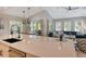 Kitchen island with sink overlooks living room and outdoor patio at 421 Pine Ave, Anna Maria, FL 34216