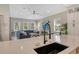 Modern kitchen with sink and breakfast bar overlooking living area at 421 Pine Ave, Anna Maria, FL 34216