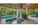 Lush, private pool and spa with covered patio and lounge chairs at 421 Pine Ave, Anna Maria, FL 34216