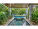 Relaxing pool and spa area with covered patio and lounge chairs at 421 Pine Ave, Anna Maria, FL 34216