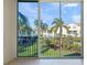 Screened balcony with view of lush landscaping and neighboring buildings at 4215 Breezeway Blvd # 2420, Sarasota, FL 34238