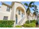 Tan two-story condo building with blue door, white stairs, and landscaping at 4215 Breezeway Blvd # 2420, Sarasota, FL 34238