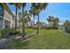 Backyard featuring manicured lawn, palm trees, and glimpses of other units at 4705 Sand Trap Street E Cir # 105, Bradenton, FL 34203