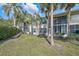 A condo featuring a well-manicured lawn, tropical trees, and screened patios providing ample outdoor space at 4705 Sand Trap Street E Cir # 105, Bradenton, FL 34203