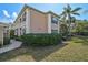 Exterior view of a two-story condo building featuring light stucco and manicured landscaping at 4705 Sand Trap Street E Cir # 105, Bradenton, FL 34203