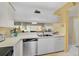 Bright kitchen featuring white cabinetry, tile floors, and stainless steel dishwasher at 4705 Sand Trap Street E Cir # 105, Bradenton, FL 34203