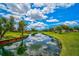 Scenic view of a tranquil pond surrounded by lush greenery, creating a peaceful and serene setting at 4705 Sand Trap Street E Cir # 105, Bradenton, FL 34203