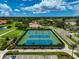 Aerial view of community tennis courts and lush landscaping in a desirable neighborhood at 4705 Sand Trap Street E Cir # 105, Bradenton, FL 34203