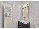 Stylish bathroom with geometric tile, gold accents, and a view to kitchen at 4940 Surfside Cir, Bradenton, FL 34211