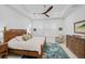 Serene bedroom with wooden bed frame, ceiling fan, and blue rug at 4940 Surfside Cir, Bradenton, FL 34211