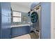 Modern laundry room with blue shaker cabinets and stainless steel appliances at 4940 Surfside Cir, Bradenton, FL 34211