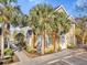 Charming multi-story townhome featuring a sunny facade and well-kept landscaping with palm trees at 5711 Soldier Cir # 204, Sarasota, FL 34233