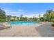 Beautiful community pool and lounge area surrounded by trees and attractive buildings under a bright blue sky at 5711 Soldier Cir # 204, Sarasota, FL 34233