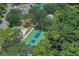 Aerial view of a green and blue basketball court surrounded by lush greenery and trees at 5827 Beaurivage Ave, Sarasota, FL 34243