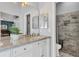 Contemporary bathroom featuring marble countertops, white cabinets, and a tiled walk-in shower at 5827 Beaurivage Ave, Sarasota, FL 34243