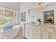 Modern bathroom featuring a soaking tub, a double vanity, a large mirror, and stylish decor at 5827 Beaurivage Ave, Sarasota, FL 34243