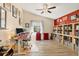 Office space with a desk, chair, bookshelves, and red accent wall, creating a functional workspace at 5827 Beaurivage Ave, Sarasota, FL 34243