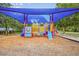 The Longwood Park playground with modern equipment, a sun shade, and soft wood chip ground cover at 5827 Beaurivage Ave, Sarasota, FL 34243