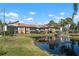 Condo building with pond view, lush landscaping, and palm trees at 6084 Red Maple Rd, Bradenton, FL 34210