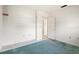 Small bedroom with teal carpet and door at 617 Whitfield Ave, Sarasota, FL 34243