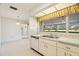 Kitchen with white cabinets and a view to the dining area at 617 Whitfield Ave, Sarasota, FL 34243