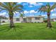 House exterior showcasing a spacious lawn and palm trees at 6228 Fordham Pl, Bradenton, FL 34207