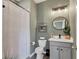 Clean bathroom with gray vanity, a shower with curtain, and white toilet at 6428 Devesta Loop, Palmetto, FL 34221