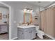 Modern bathroom with gray vanity, a shower with curtain, and wood-look tile floor at 6428 Devesta Loop, Palmetto, FL 34221