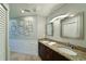 Double vanity bathroom with granite countertops and a large mirror at 6589 Fairway Gardens Dr, Bradenton, FL 34203