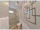 Bathroom with a walk-in shower, toilet, and a geometric wall accent at 6589 Fairway Gardens Dr, Bradenton, FL 34203