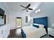 Main bedroom with a blue upholstered bed, ceiling fan, and access to a private balcony at 6589 Fairway Gardens Dr, Bradenton, FL 34203