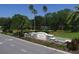 Edgewater Village entrance with lush landscaping and a pond at 6669 Windjammer Pl, Lakewood Ranch, FL 34202