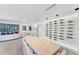 Modern dining room with a light wood table and a glass wine wall at 6669 Windjammer Pl, Lakewood Ranch, FL 34202