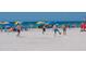 Beach scene with people playing soccer and relaxing under umbrellas at 709 Key Royale Dr, Holmes Beach, FL 34217