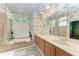 Double vanity bathroom with bamboo wallpaper and a relaxing soaking tub at 7215 Treymore Ct, Sarasota, FL 34243