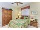 Bedroom with a floral comforter, wood furniture, and a window with blinds at 7215 Treymore Ct, Sarasota, FL 34243