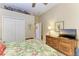 Main bedroom with a floral comforter, dresser, and a TV at 7215 Treymore Ct, Sarasota, FL 34243