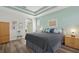 King-size bed in a well-lit bedroom with light teal walls and wood-look floors at 7302 Deer Crossing Ct, Sarasota, FL 34240