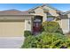 Tan house exterior with a red door and landscaping at 7302 Deer Crossing Ct, Sarasota, FL 34240