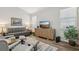 Bright living room with gray sofa and wood media console at 7302 Deer Crossing Ct, Sarasota, FL 34240