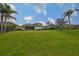 Expansive green backyard with a partial view of the rear exterior of the home with a screened in porch at 8030 Hampton Lake Dr, Tampa, FL 33647